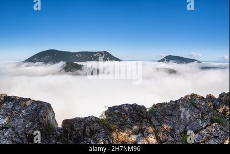view from the rocky cliff to the hills, inversion in the valley, breathtaking atmosphere Stock Photo