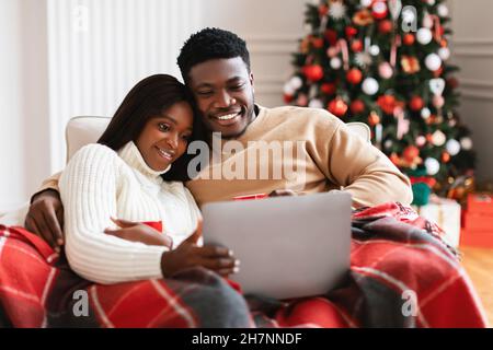 Portrait of happy black family watching tv on laptop Stock Photo