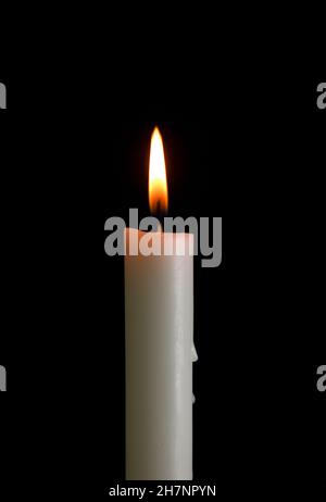 One candle with light isolated on a black background. Stock Photo