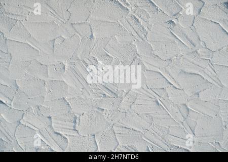 Messy plastered wall, painted white. Backgrounds and textures. Stock Photo
