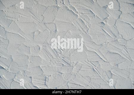 Messy plastered wall, painted white. Backgrounds and textures. Stock Photo