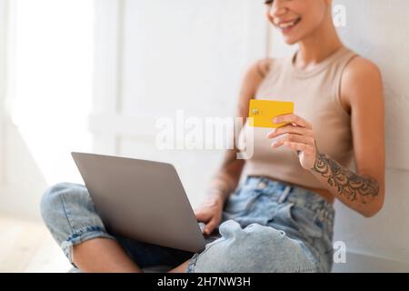 Online shopping, remote banking concept. Lady with credit card and laptop computer buying goods on internet Stock Photo