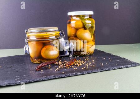 Two jars of eggs pickled in  dark malt vinegar, landscape with copyspace. Stock Photo