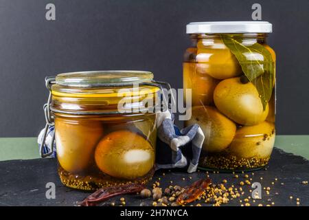 Two jars of eggs pickled in  dark malt vinegar, landscape. Stock Photo