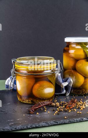 Two jars of eggs pickled in  dark malt vinegar, portrait with copyspace. Stock Photo