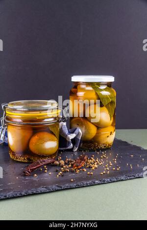 Two jars of eggs pickled in  dark malt vinegar, portrait with copyspace at top. Stock Photo