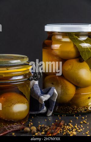 Two jars of eggs pickled in  dark malt vinegar, portrait with close up. Stock Photo