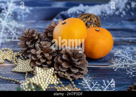 Tangerines on a gray background with branches of a Christmas tree, in the background a window with snow. New year concept. Copy space. Stock Photo