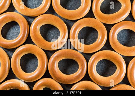 Ukrainian, Russian and Belarusian traditional bakery food fresh delicious bread rings (bagels, sushki or baranki), isolated on dark background. Stock Photo