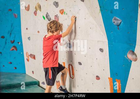 Boy at the climbing wall without a helmet, danger at the climbing wall Stock Photo