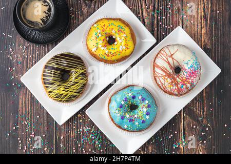 Delicious donuts decorated with different decorations on wooden table Stock Photo