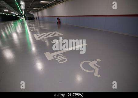 Shallow depth of field (selective focus) image with parking lots for people with disabilities inside an underground parking. Stock Photo