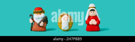 the holy family, formed by the child jesus, the virgin mary and saint joseph, on a blue background, in a panoramic format to use as web banner or head Stock Photo