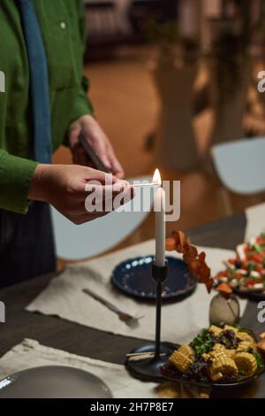 Close-up of man lighting candle on dining table and preparing for dinner party Stock Photo