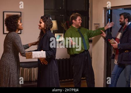 Young couple visiting their friends, they coming to home, embracing and giving presents Stock Photo