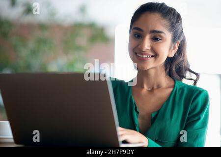 Positive millennial arabic lady looking for job online, closeup Stock Photo
