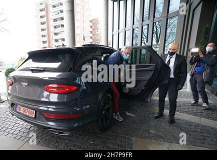 24 November 2021, Hamburg: Chauffeur Mazi Salimi (2nd from right) opens the door of the luxury SUV Bentley Bantayga Hybrid to a vaccinated person in front of the Empire Riverside Hotel at the port of Hamburg. On Wednesday, people who want to be vaccinated against Corona could be chauffeured to their appointment in a luxury car in Hamburg. After the vaccination in the Skyline Bar 20up on the 20th floor of the hotel, there was a great view over Hamburg as well as an alcohol-free cocktail. Several Hamburg companies wanted to use this action as an incentive for the vaccination against Corona. Phot Stock Photo