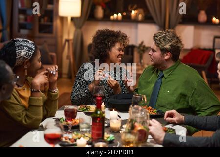 Group of friends having fun while sitting at dining table during dinner party Stock Photo