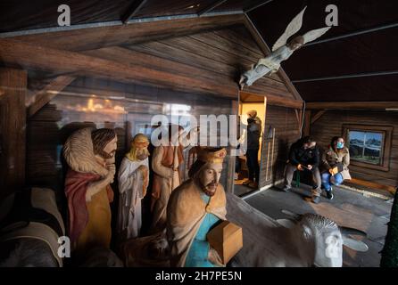 Offenbach Am Main, Germany. 24th Nov, 2021. People willing to be vaccinated wait in front of the temporary vaccination station in the nativity scene of the Christmas market in Offenbach for their vaccination against the Corona virus. To make room for the people, the giant nativity figures were moved aside. Credit: Boris Roessler/dpa/Alamy Live News Stock Photo