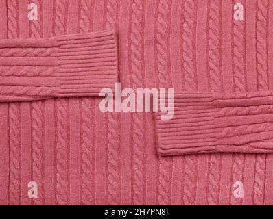 Close up background texture of pink cable knitted wool jersey fabric sweater with row braid pattern Stock Photo
