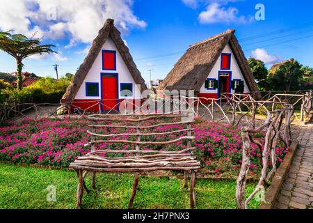 Madeira island travel and landmarks. Charming traditional colorful houses with thatched roofs in Santana town, popular tourist attraction in Portugal Stock Photo