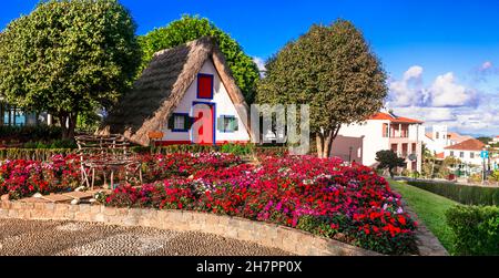 Madeira travel and landmarks. Charming traditional colorful houses with thatched roofs in Santana town, popular tourist attraction in Portugal Stock Photo