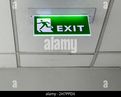 The green fire exit symbol on the ceiling shows escape routes outside the building when the fire, front view with the copy space. Stock Photo