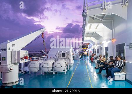 Passengers on board of ferry boat Kydon from San Juan in Puerto Rico to Santo Domingo in the Dominican Republic at sunset, Greater Antilles, Caribbean Stock Photo