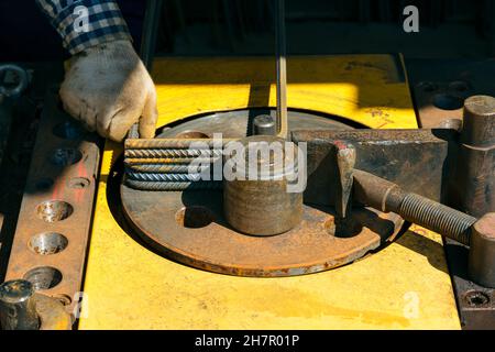 Rebars with rebar bending machine in the site. Worker using bending rebar machine for reinforcement in the construction work Stock Photo