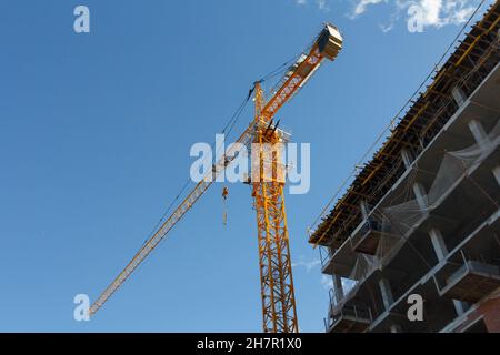 Tower crane on a background of blue sky. Construction crane at a construction site. Heavy Duty Lifting Equipment Stock Photo