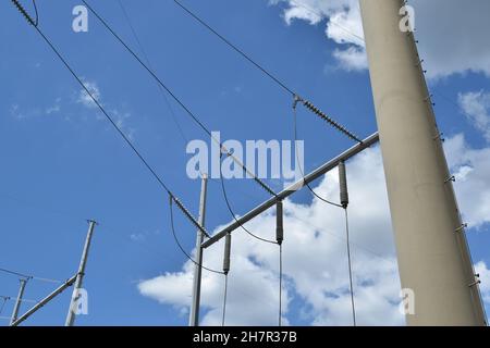 Dangerous high voltage power lines overhead connect to the grid. Stock Photo