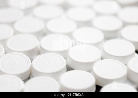 full frame close-up background filled with white HDPE - High Density Poly Ethylene plastic bottle caps Stock Photo