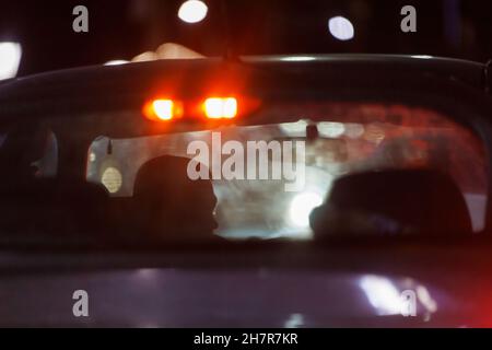 unrecognizable car driver in night traffic jam - view from behing outside Stock Photo