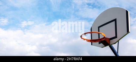 Basketball hoop without a net on cloudy sky simple abstract sport wide blank empty background texture, copy space, wide banner. Sports, leisure activi Stock Photo