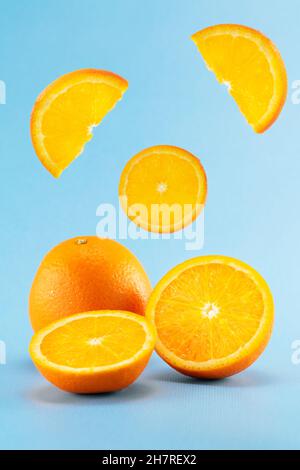 composition of oranges on a blue background pieces levitate in the air Stock Photo