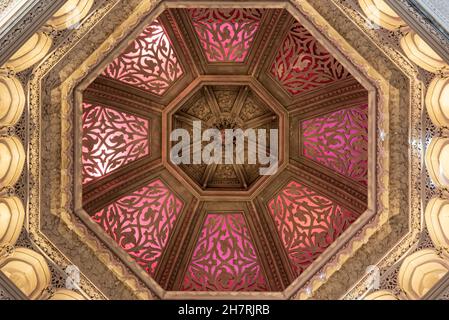 Rose coloured octagonal shaped glass ceiling skylight in islamic style architecture interior multi-level courtyard with encircling balustrades and arc Stock Photo