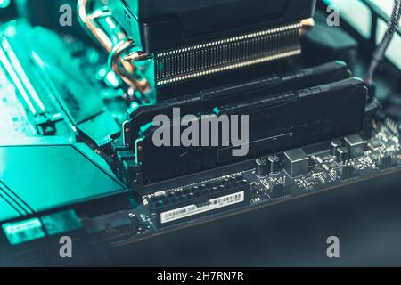 Two memory banks on a computer mainboard in teal and white light Stock Photo