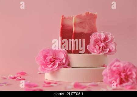 Rose soap. Beauty and aromatherapy. Flower soap. Pink soap bars and pink roses on pink background. Stock Photo