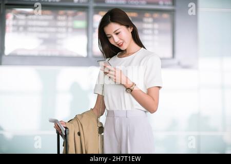 Business woman using a mobile phone at the airport Stock Photo
