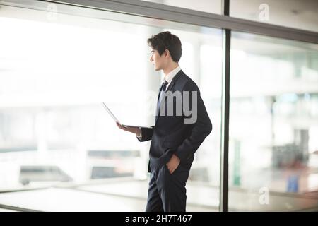 Young business man using a laptop in an airport lounge Stock Photo