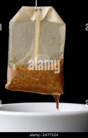 tea bag with a ceramic white cup isolated on black background, closeup Stock Photo
