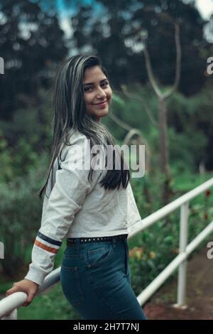 Young attractive Colombian female wearing a white shirt and jeans