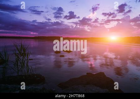 The soft cloudy sky is a gradient pastel, abstract background of a sweet-colored sky.The water is calm without waves. High quality photo Stock Photo