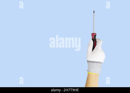 Gloved hands holding screwdriver construction tools. Work tools on blue background Stock Photo