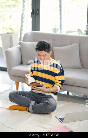 Asian student with laptop preparing for exam at home Stock Photo