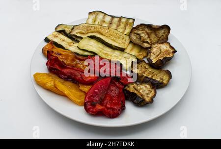 Grilled mix of vegetables in a dish isolated on white background. Stock Photo