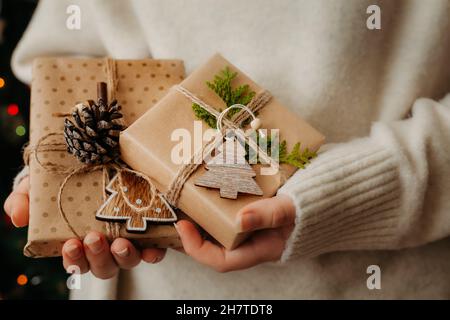 Two small gift boxes in female hands. Close up. Nice presents wrapped in craft paper, zero waste concept Stock Photo