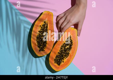 Papaya summer food background. Juicy exotic tropical papaya with shadows of palm tree branches. Summer, vitamins, fruits, sun concept. High quality photo Stock Photo