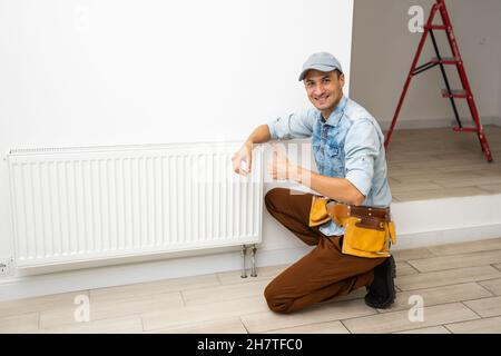 Close-up Of Male Plumber Fixing Thermostat Using Wrench At Home. Stock Photo