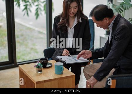 Friendly lawyer or financial advisor in suit consulting elder man, smiling investment broker or bank worker making loan offer, giving legal advice Stock Photo